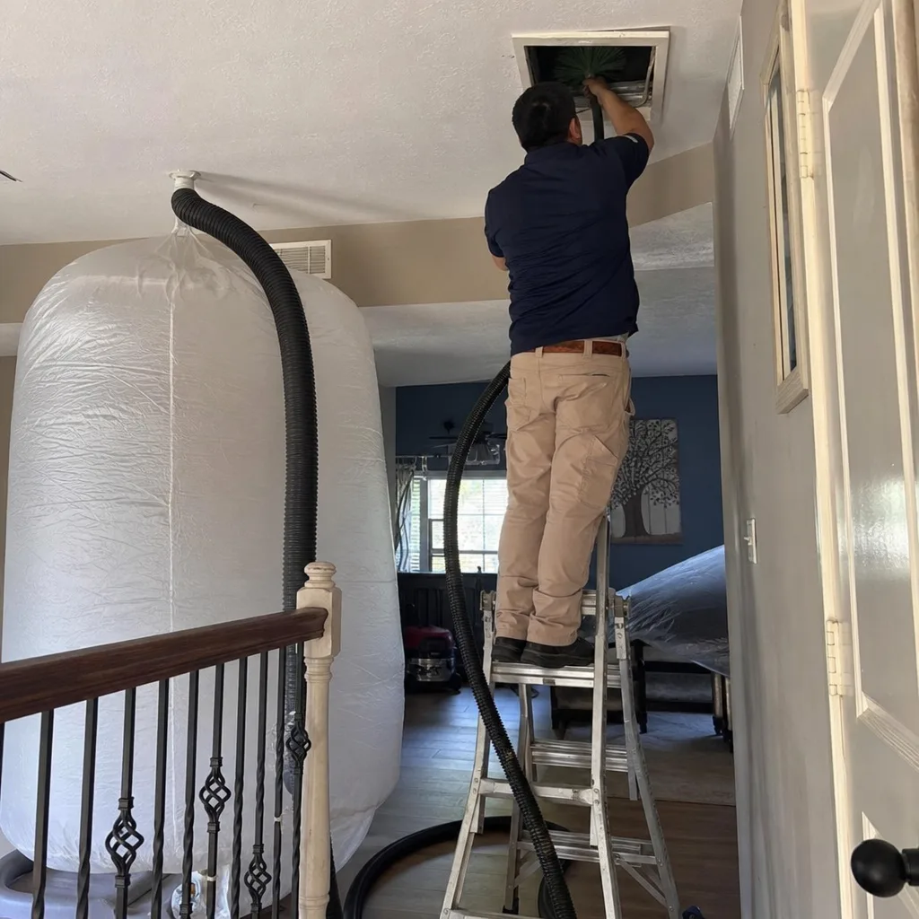 Technician performing professional residential air duct cleaning service